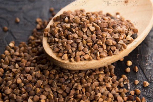 Buckwheat seeds on wooden spoon in closeup, lodz, poland