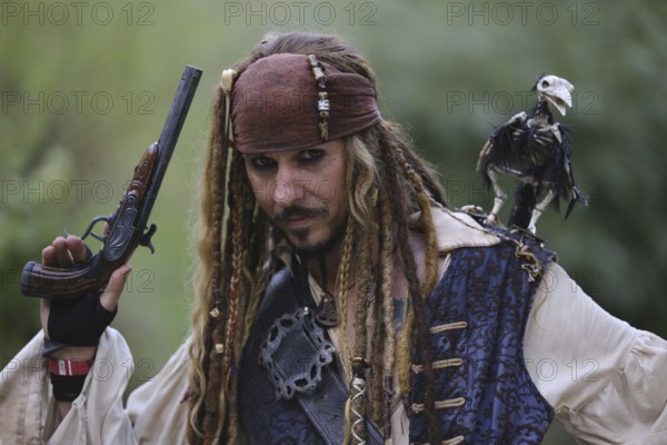 Man in pirate costume with bird on his shoulder