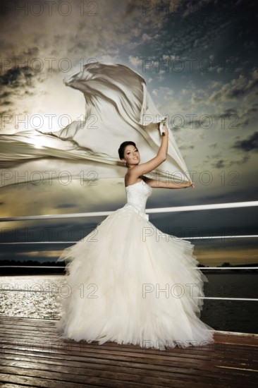 Pretty lady in a wedding dress on deck