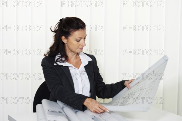 Architect with building plan in the office. Plans of a residential building are being processed Austria