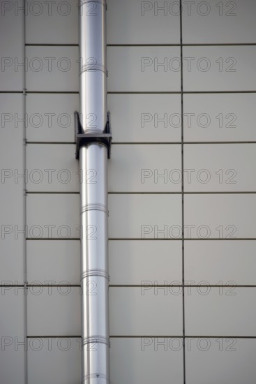 A mounted stainless steel pipe on a symmetrically arranged sheet metal façade