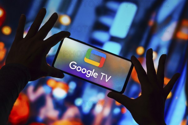 In this photo illustration, the Google TV logo is displayed on a smartphone screen