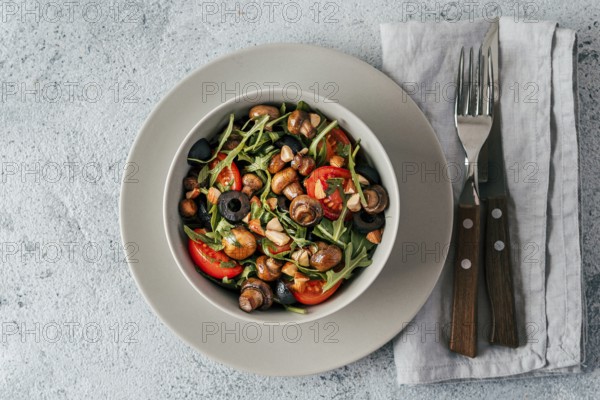 Salad with arugula, mini champignons, cherry tomatoes, black olives, pine nuts. Vegetarian salad top view or flat lay. Copy space. Horizontal banner