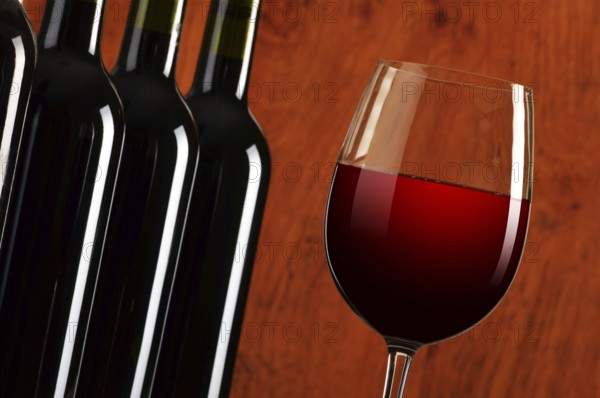 Composition with wineglass and bottles of red wine
