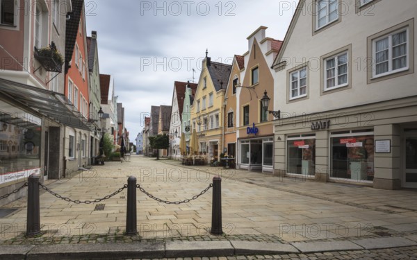 An empty shopping street with historic buildings and shop fronts under a cloudy sky, pedestrian zone Mindelheim, Bavaria, Germany, Europe