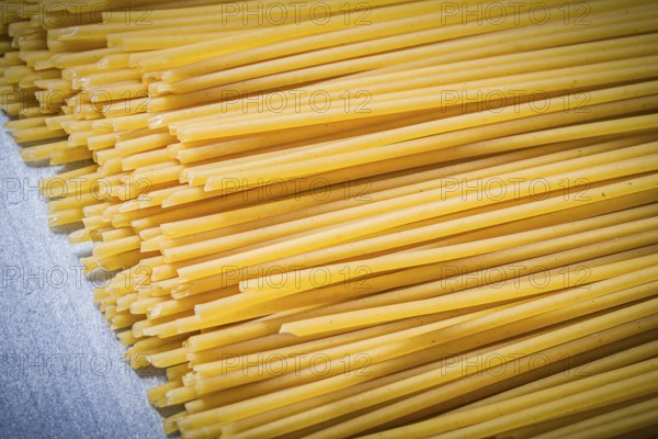Heap of thin spaghetti on blue background directly above food and drink concept