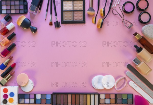 Cosmetics makeup lipstick eye shadows arrangement on pink table