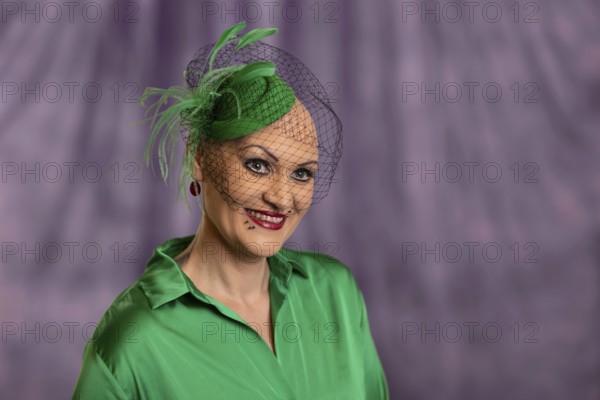 Woman smiling with green hat and net in front of purple background, Staged portrait shoot, Studio shot, Mindelheim, Bavaria, Germany, Europe