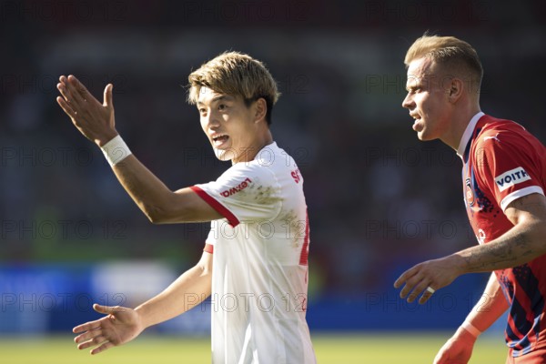 Football match, Ritsu DOAN SC Freiburg left with raised left arm shouting towards linesman, Lennard MALONEY 1. FC Heidenheim in waiting position, Voith-Arena football stadium, Heidenheim