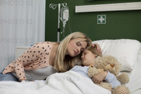 A loving mother gently comforts her sick child, who is lying in a hospital bed, creating a truly heartwarming moment