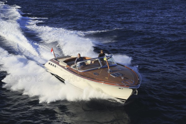 Aerial view sports boat J Craft 42 Torpedo R at full speed on the Cote d'Azur, luxurious motorboat from the Swedish shipyard J Craft Boats with Volvo Penta engine in vintage style of the 50s and 60s in the style of the Riva boats, Mediterranean Sea