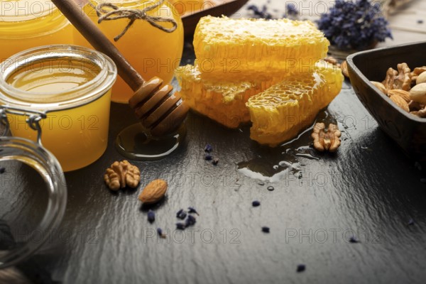 Honeycomb on slate tray with honey and nuts on kitchen table, food photography, food photography