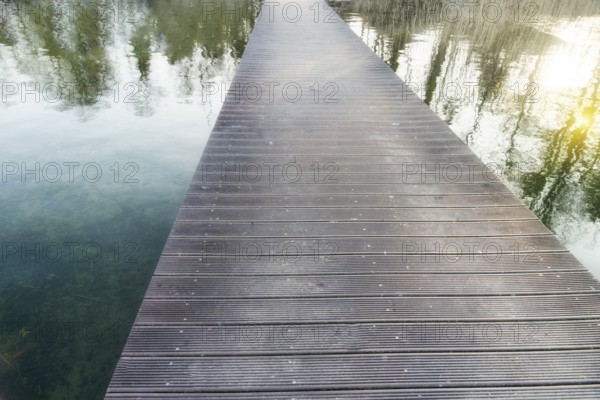 Infinitely long pedestrian bridge over a lake with reflections