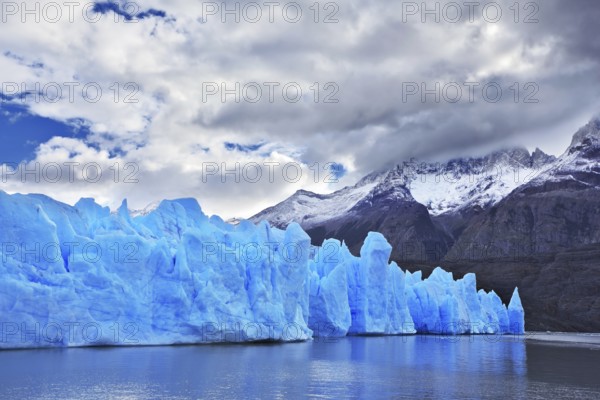 Chilean Patagonia. National Park Torres del Paine. Lake and Glacier Grey. The clouds covered the sun cold. Grey glacier moves down the water of the lake