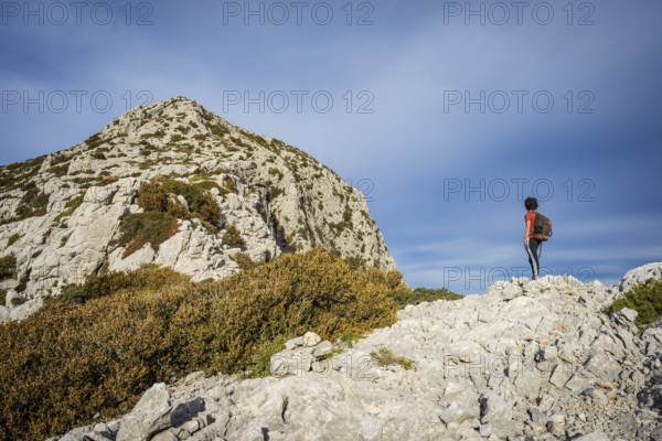 Hiker ascending Puig Galatzo, dry stone path, GR221, Calvia, Natural area of the Serra de Tramuntana, Majorca, Spain, Europe