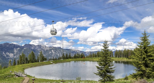 Small lake on the Planai with gondola lift. Smal water reservoir on a mountain by schladming, planai