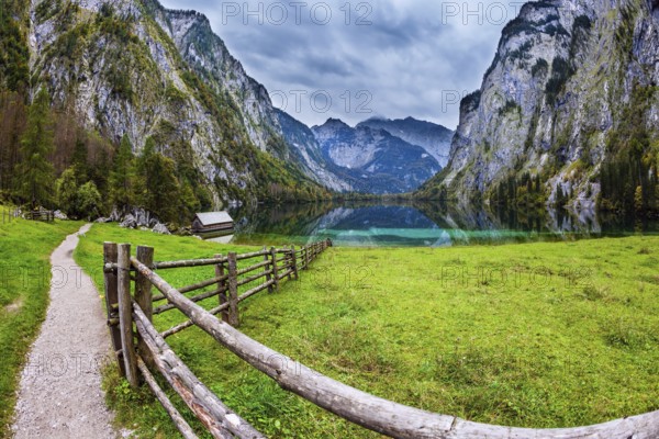 The concept of active tourism and ecotourism. Bavarian Alps. Magic blue lake Obersee and fenced path to it