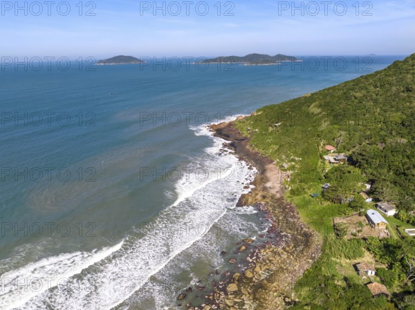 Coastline with beach, mountains and blue ocean with waves in Brazil. Aerial view of Saquinho beach. Florianopolis Santa Catarina. SC