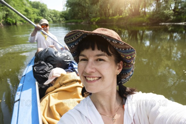 Man and woman couple, baby is sleeping, selfies are happy in family kayak trip rowing boat on the river, water hike, a summer adventure. Eco-friendly and extreme tourism, active and healthy lifestyle