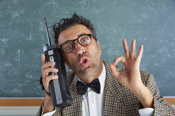 Nerd silly private investigator with retro walkie talkie on teacher balckboard