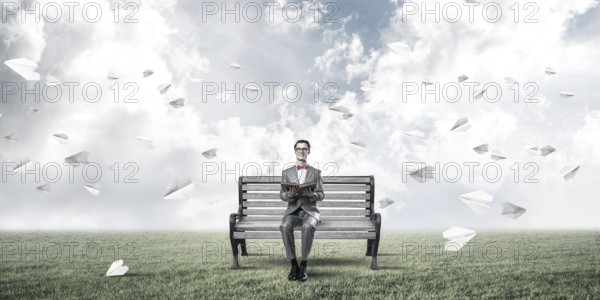 Young businessman or student studying the science and paper planes fly around