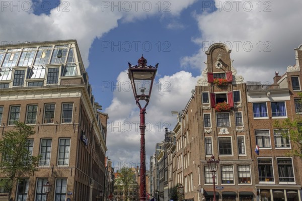 Street lamp in a historic city centre under a blue sky with clouds, Amsterdam, Netherlands