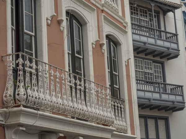 Detailed view of an old building façade with ornate balconies and windows. The colours are muted, la palma, canary islands, spain