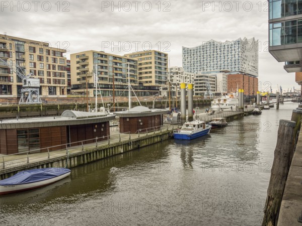 View of the harbour with various boats, modern buildings and the Elbe Philharmonic Hall in cloudy weather, Hamburg, Germany, Europe