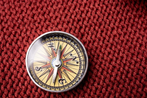 Compass tool on red texture fabric