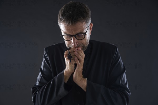 Priest praying hands with rosary beads male