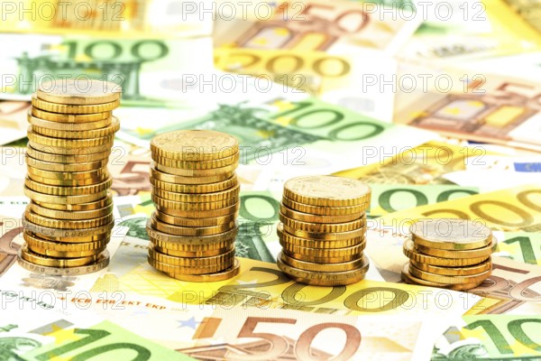 Stack of coins, falling curve, symbolic photo for falling interest rates and falling costs