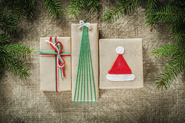 Set of fir tree branches handmade gift boxes on burlap background