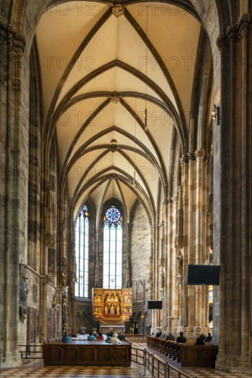 Vienna, Austria, 22 September, 2022: people praying during a church service in one of the side chapels of the historic St. Stephen's Cathedral in Vienna, Europe