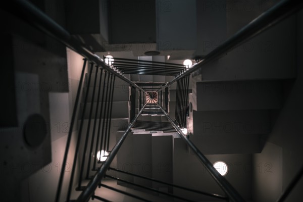 Abstract architectural image with a modern staircase on many levels, viewed from down to up, with artificial low light, in Karlsruhe, Germany, Europe