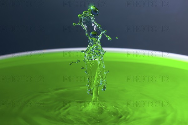 A powerful splash of green liquid with eye-catching water sculptures, water droplets, collision, high-speed photography, concept