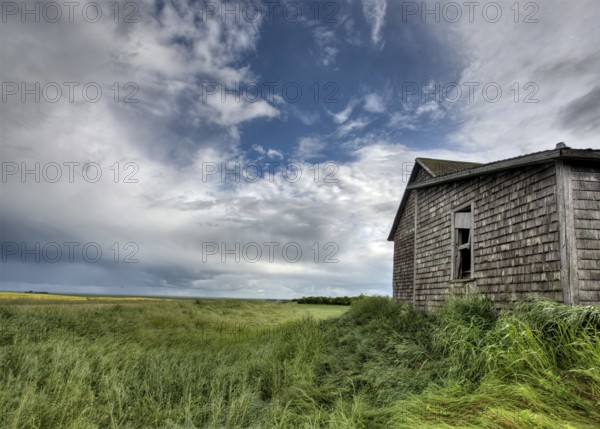 Abandoned Farm with storm clouds in the Canadian Prairie