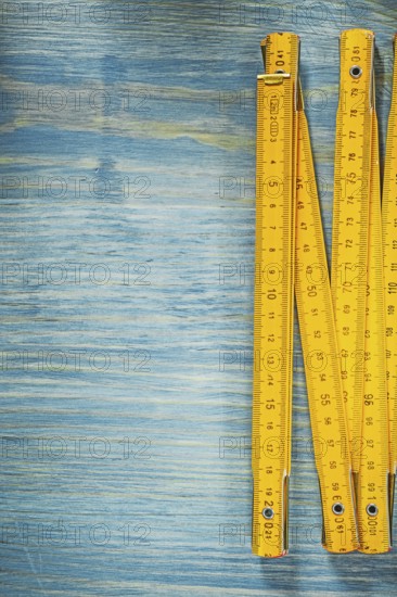 Yellow wooden meter on vintage wood surface construction concept