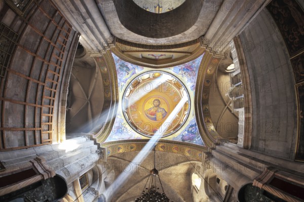 Facilities in the Holy Sepulchre. The magnificent round arch of a ceiling is shined with two bright beams of the sun. On a ceiling image of the Christ Savior