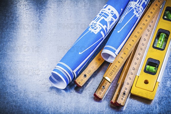Blue engineering drawings wooden meter construction level on metallic background