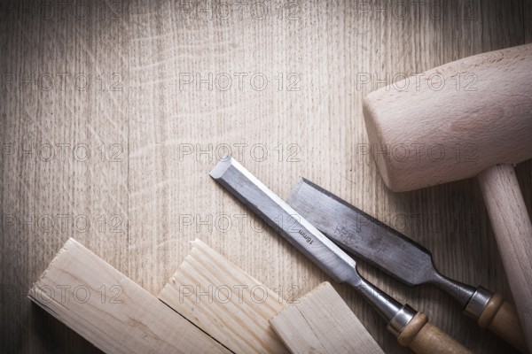 Wooden bricks mallets flat chisels on wood background close up view construction concept