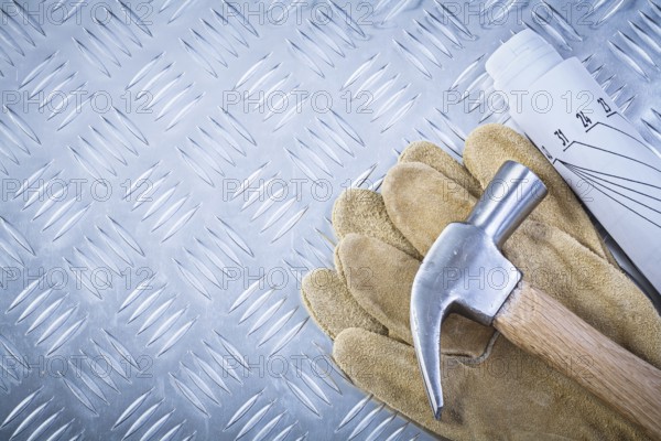 Claw hammer leather safety gloves blueprints on fluted metal sheet construction concept
