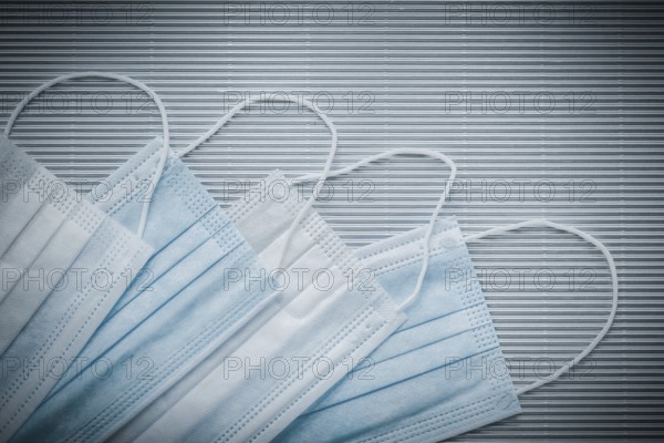 Set of disposable medical flu masks on a striped background