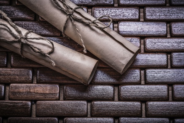Antique paper rolls with string on a wicker placemat