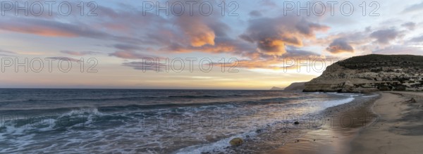 A beautiful panorama ocean sunset on the Costa del Sol in Spain with beach and cliffs in the background