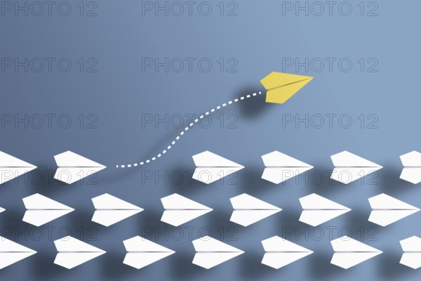 paper planes in a row on blue background and one paper glider going in different direction, breaking new ground and stepping out of the line concept