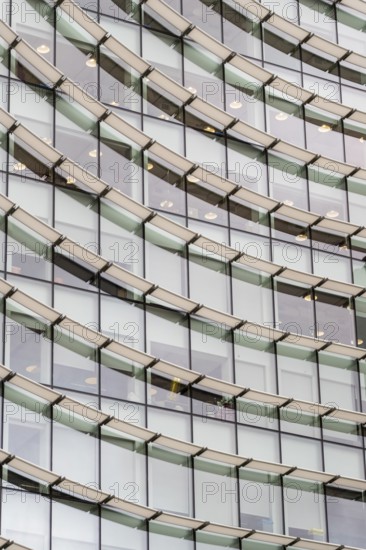 Abstract mosaic of geometric shapes adorns the modern building's facade, doubling as a captivating backdrop, creating a mesmerizing repetitive pattern