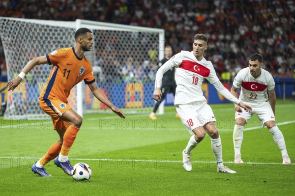 BERLIN, GERMANY - JULY 6, 2024: Euro 2024 quarterfinal match Nederlands vs Turkey (Turkiye) 2:1. In action Cody Gakpo (L) Mert Muldur (M) Kaan Ayhan (R)