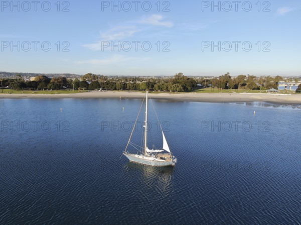 Aerial view of small sail boats in the Mission Bay of San Diego, California, USA. Small sailing ship yachts anchored in the bay. March 22nd, 2020