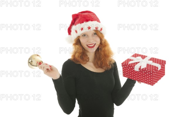 Young red haired woman with Christmas gift and bell of Santa Claus
