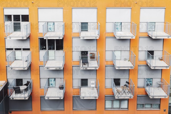 College dorm from outside, view of an orange building with grey balconies. A building where students come to live during their studies